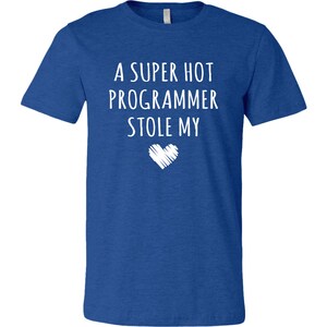 Pu&ograve; includere: Una t-shirt blu reale con il testo "A super hot programmer stole my" e una grafica a forma di cuore bianca.