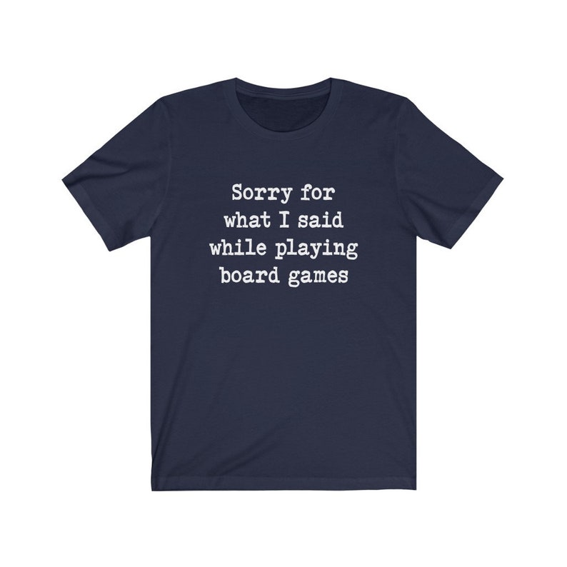 May include: A navy blue t-shirt with white text that reads "Sorry for what I said while playing board games".