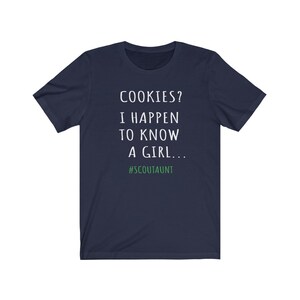May include: Navy blue t-shirt with white text that reads "COOKIES? I HAPPEN TO KNOW A GIRL... #SCOUTAUNT"
