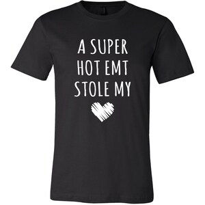 May include: Black t-shirt with white text that reads "A super hot EMT stole my heart".