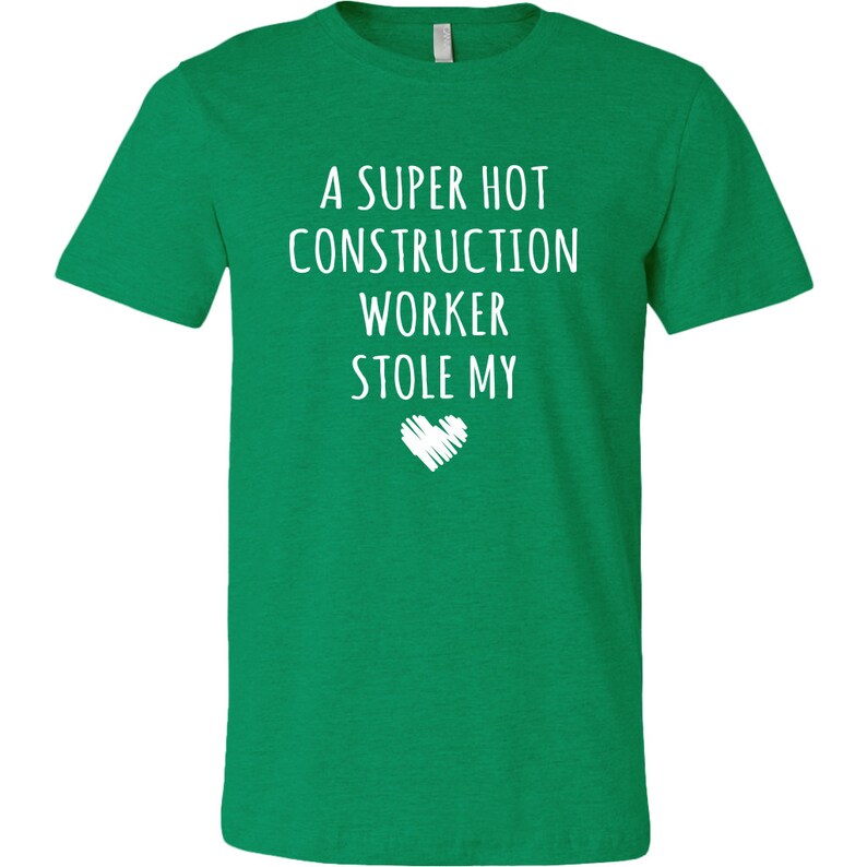 May include: A green t-shirt with the text "A super hot construction worker stole my" and a white heart.