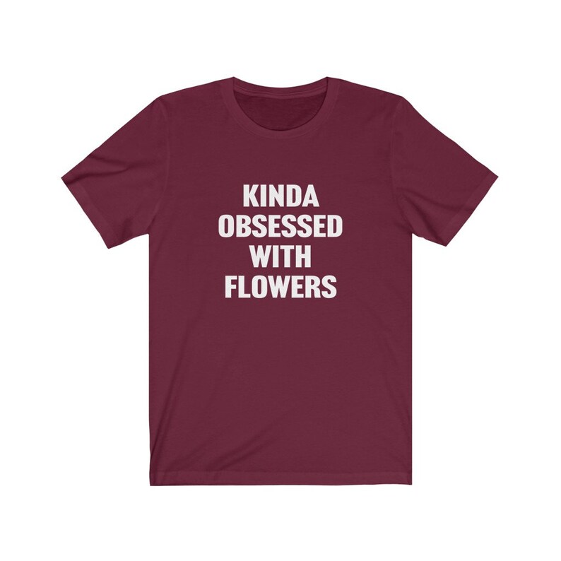 Puede incluir: Camiseta de manga corta color burdeos con texto blanco que dice "Kinda obsessed with flowers".