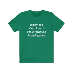May include: A green t-shirt with the text "Sorry for what I said while playing board games" in white.
