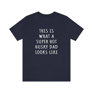May include: A navy blue t-shirt with white text that reads "This is what a super hot husky dad looks like."