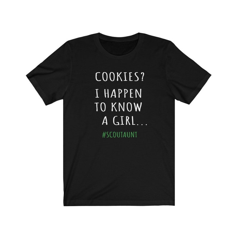 May include: Black t-shirt with white text that reads "COOKIES? I HAPPEN TO KNOW A GIRL... #SCOUTAUNT"