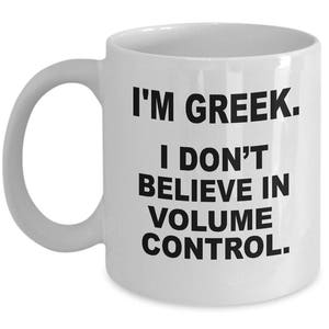 May include: White ceramic coffee mug with black text that reads "I'm Greek. I don't believe in volume control."