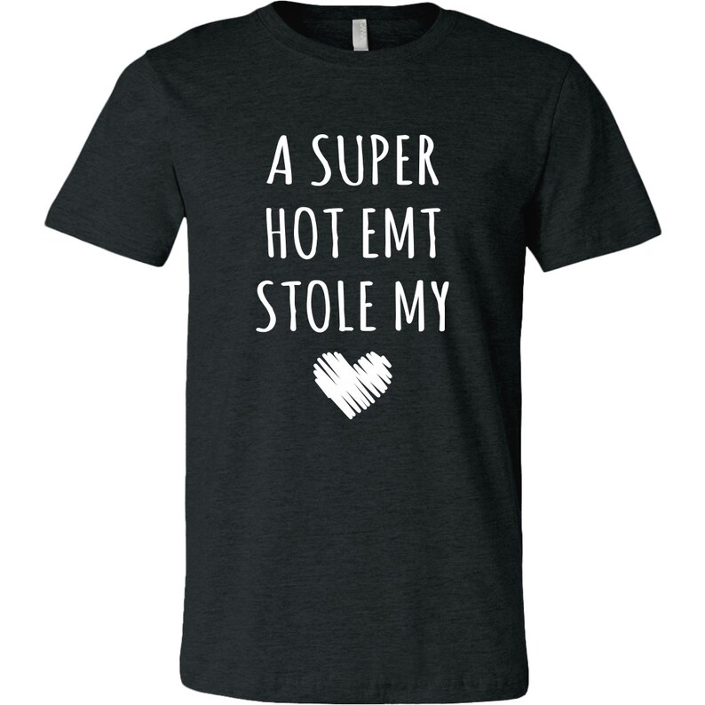 May include: A dark heather grey t-shirt with the text "A super hot EMT stole my" and a white heart graphic.