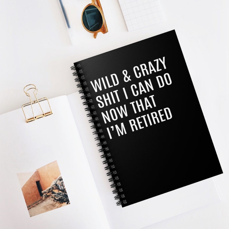 May include: Black spiral bound notebook with white text that reads "Wild & Crazy Shit I Can Do Now That I'm Retired".