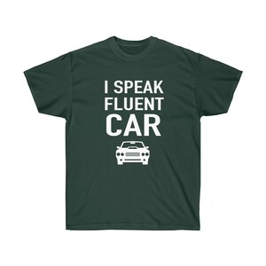 K&ouml;nnte beinhalten: Dunkelgr&uuml;nes T-Shirt mit dem wei&szlig;en Text "I SPEAK FLUENT CAR" und einer wei&szlig;en Autografik. Das T-Shirt ist einfarbig und hat einen Rundhalsausschnitt.