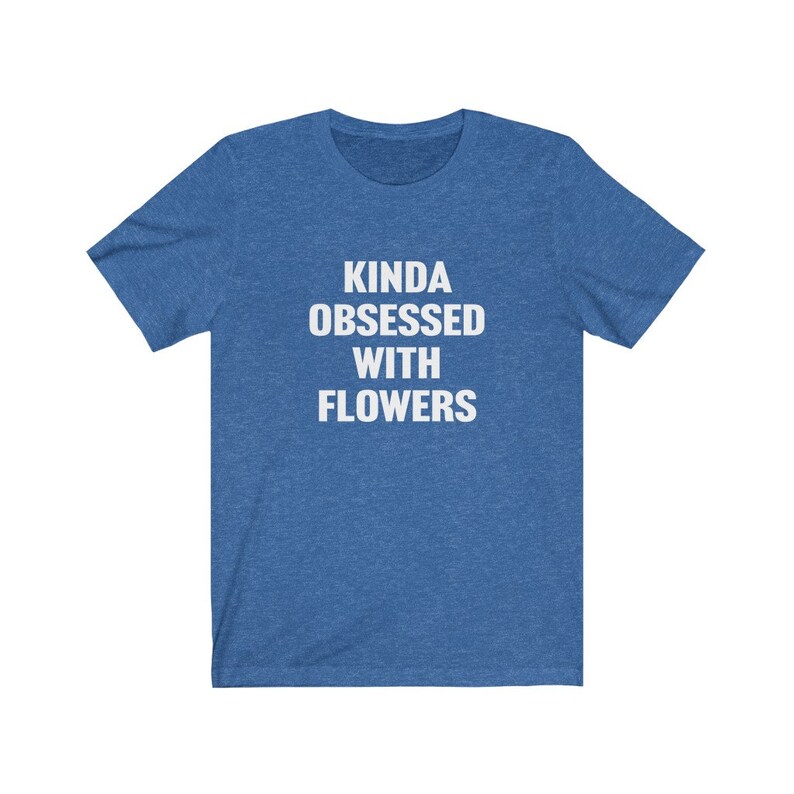 Puede incluir: Una camiseta azul con el texto "Kinda obsessed with flowers" en blanco.