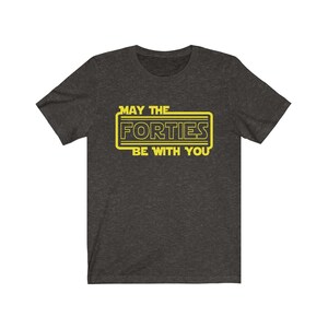 May include: A dark heather grey t-shirt with a yellow graphic that says "May the Forties Be With You".