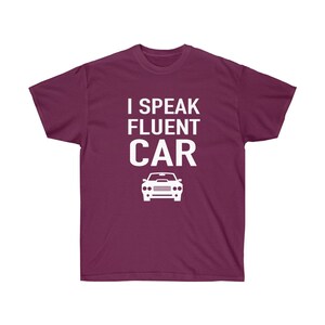 K&ouml;nnte beinhalten: Burgunderfarbenes T-Shirt mit dem wei&szlig;en Text "I Speak Fluent Car" und einer wei&szlig;en Autografik. Das Shirt hat einen Rundhalsausschnitt und ist einfarbig.