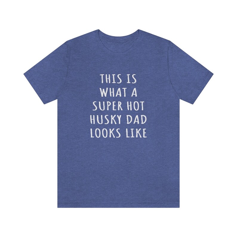 May include: A blue heather t-shirt with the text "This is what a super hot husky dad looks like" printed in white.