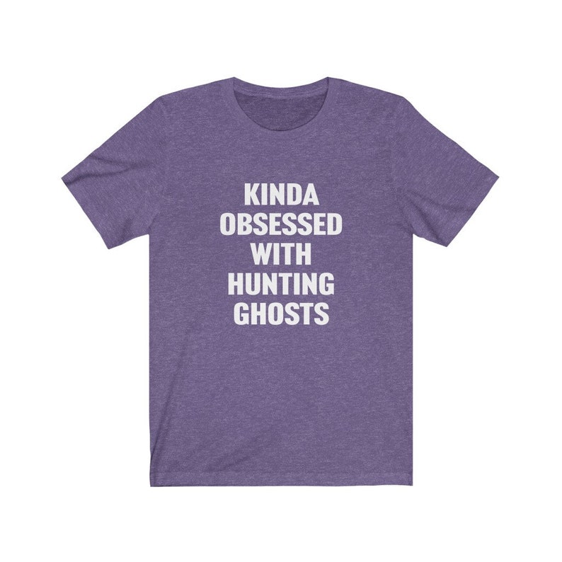 May include: Purple short-sleeved t-shirt with white text that reads "Kinda obsessed with hunting ghosts".