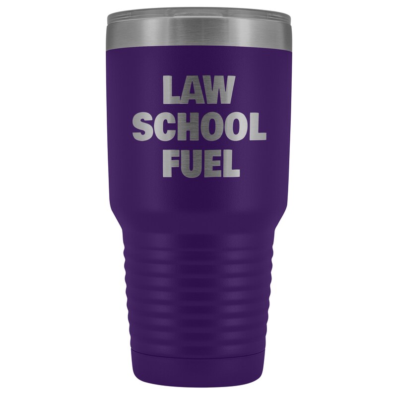 May include: Purple stainless steel tumbler with a silver inscription that reads "LAW SCHOOL FUEL".
