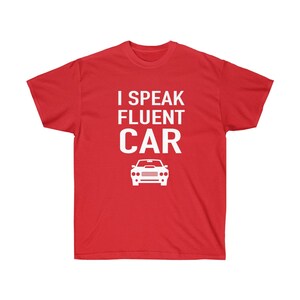 K&ouml;nnte beinhalten: Ein rotes T-Shirt mit dem wei&szlig;en Text "I Speak Fluent Car" und einer wei&szlig;en Autografik. Das T-Shirt ist einfarbig und hat einen Rundhalsausschnitt.