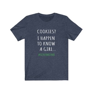 May include: A navy blue t-shirt with white text that reads "COOKIES? I HAPPEN TO KNOW A GIRL... #SCOUTBROTHER".