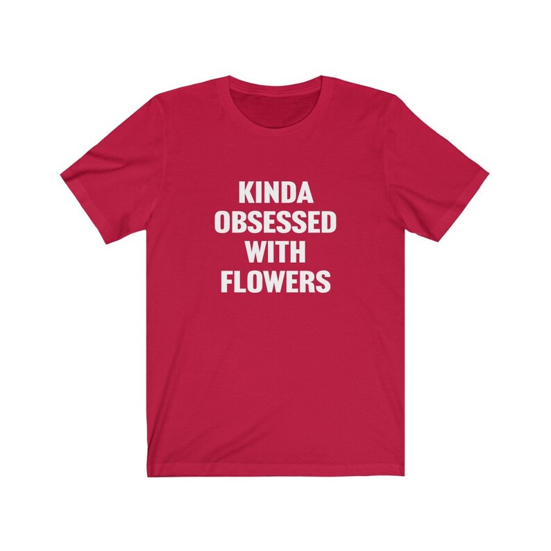 Puede incluir: Camiseta roja de manga corta con el texto "Kinda obsessed with flowers" en blanco.