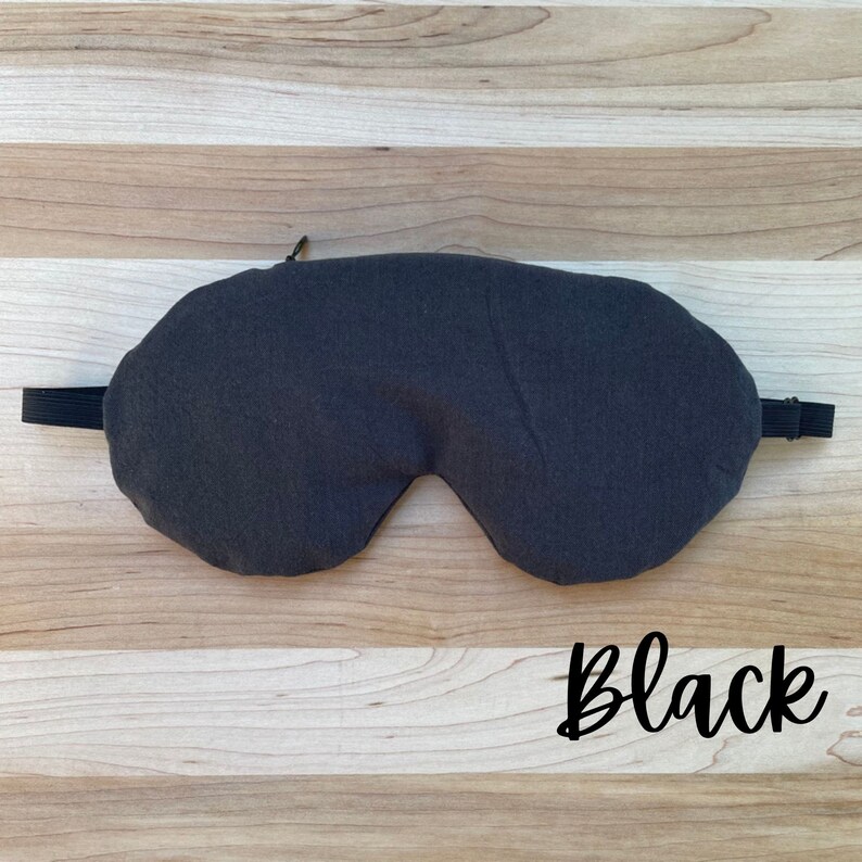 May include: A black sleep mask with an elastic strap. The mask is made of a soft, comfortable fabric.