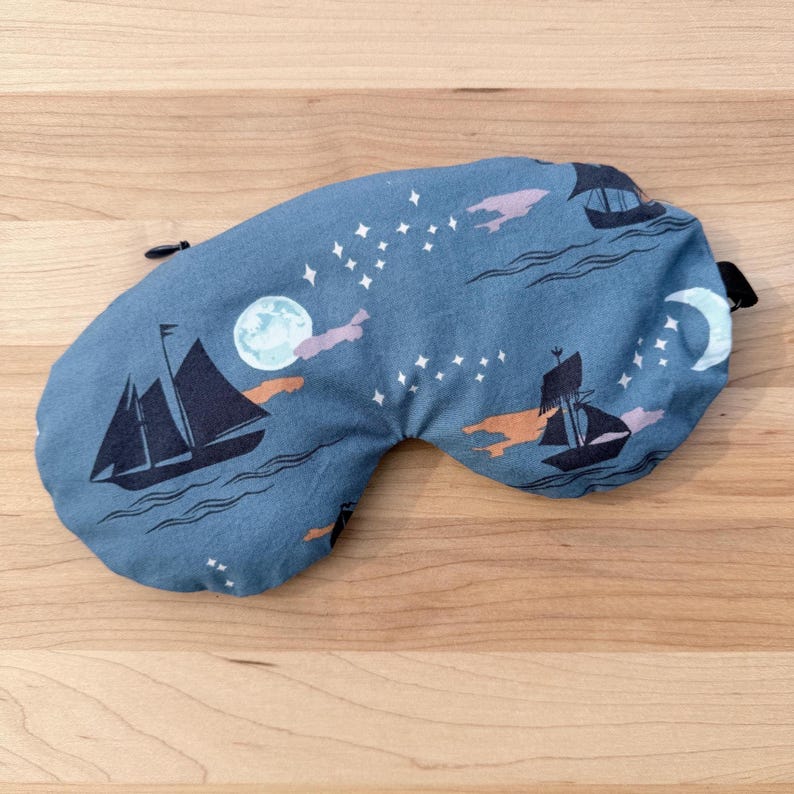 Puede incluir: Una m&aacute;scara para dormir azul con un dise&ntilde;o n&aacute;utico. La m&aacute;scara presenta veleros negros, estrellas, una luna y nubes. Tiene una correa el&aacute;stica negra. Dise&ntilde;ada para bloquear la luz y mejorar el descanso.