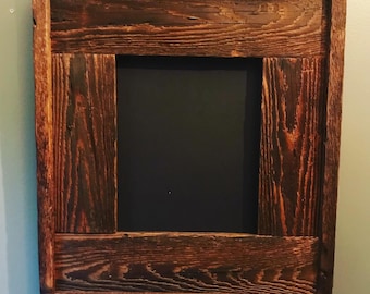 May include: A dark brown wooden frame with a black chalkboard insert. The frame is made of reclaimed wood with a rustic finish.