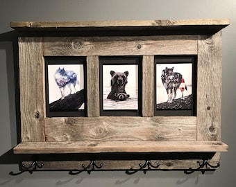 May include: Rustic wooden wall shelf with three framed animal prints and four hooks. The prints feature a wolf, a bear, and a wolf with a red life preserver.