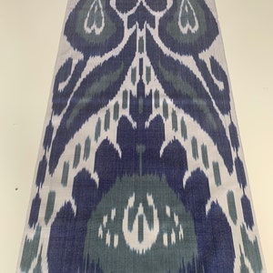 Puede incluir: Una tela blanca con un patr&oacute;n ikat azul y verde. El patr&oacute;n es un dise&ntilde;o tradicional con un motivo repetitivo de hojas y flores.
