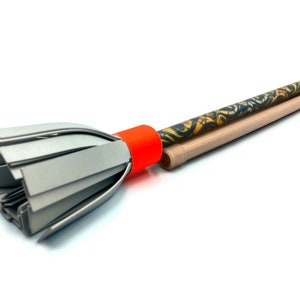 May include: A gray paper broom with a red handle and a brown and gold patterned stick.