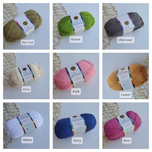 K&ouml;nnte beinhalten: Neun Str&auml;nge Lion Brand 24/7 Baumwollgarn in verschiedenen Farben. Farben sind Bay Leaf, Grass, Charcoal, Ecru, Pink, Camel, White, Navy und Rose. Jeder Strang hat ein Etikett mit dem Markennamen und der Garnart.