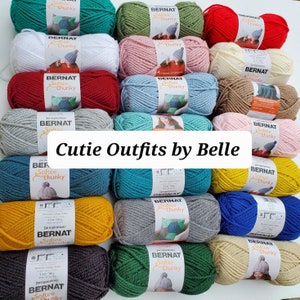 May include: A collection of yarn skeins in various colors, including red, white, green, blue, yellow, and brown. The yarn is labeled "Bernat Softee Chunky" and is arranged in a grid pattern. The text "Cutie Outfits by Belle" is written in white letters on a white background.