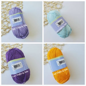 May include: Four skeins of EULALI yarn in various colors: lavender, light blue, purple, and mango. Each skein has a label with the brand name and color information. The text "Cutie Outfits by Belle" is printed on the bottom of each skein.