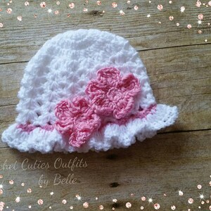 May include: White crocheted sun hat with a pink crocheted flower embellishment. Crochet Cuties Outfits by Belle.