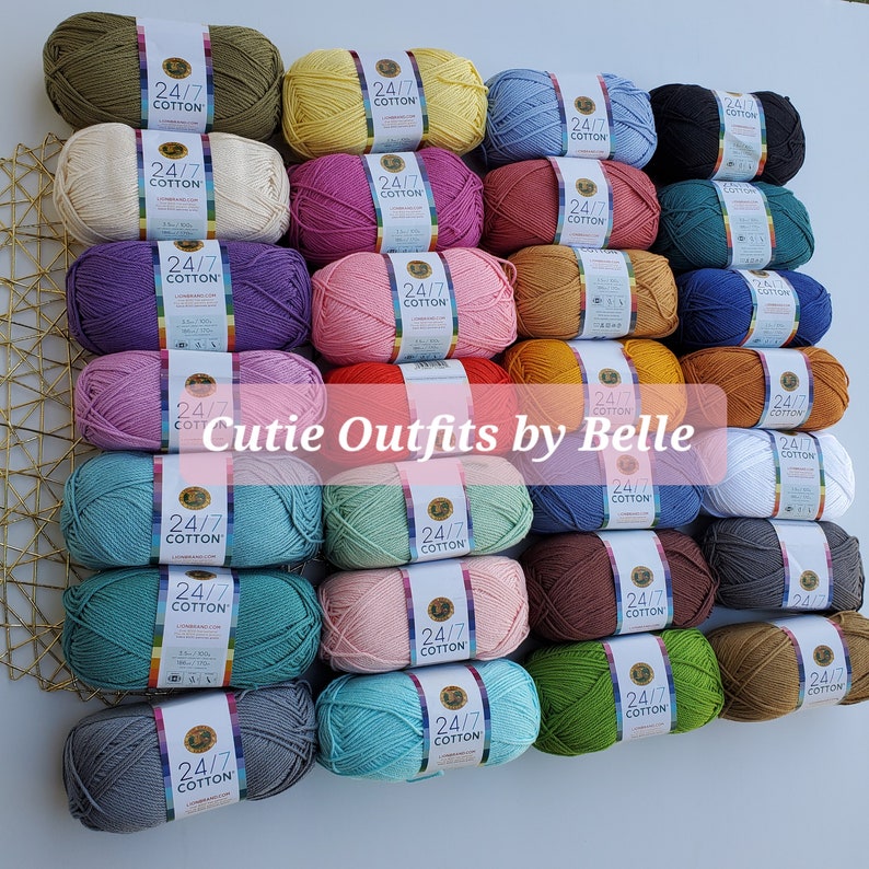 K&ouml;nnte beinhalten: Eine Sammlung bunter Garnkn&auml;uel in verschiedenen Farbt&ouml;nen, darunter Gr&uuml;n, Gelb, Rosa und Blau. Jedes Kn&auml;uel ist mit "24/7 COTTON" beschriftet und ordentlich angeordnet. Der Text "Cutie Outfits by Belle" ist auf dem Bild &uuml;berlagert.