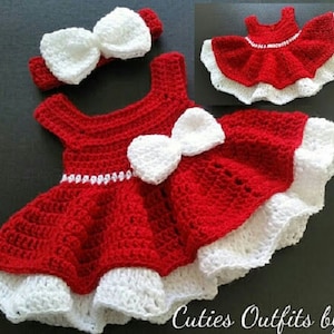 Pode incluir: Vestido de beb&eacute; de croch&ecirc; vermelho com acabamento de croch&ecirc; branco e um la&ccedil;o branco. O vestido tem uma faixa de cabe&ccedil;a de croch&ecirc; branco com um la&ccedil;o.