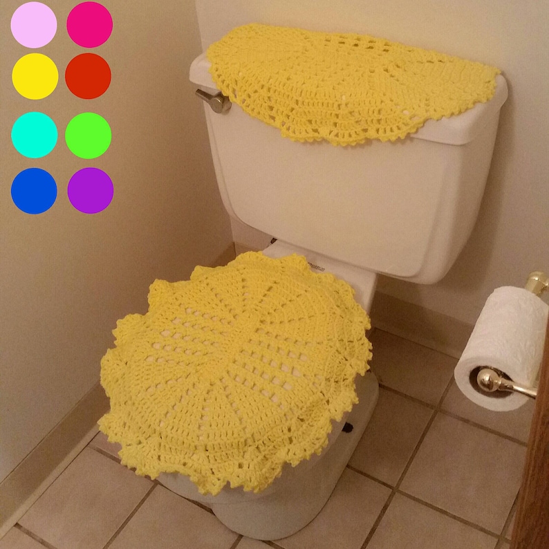 May include: A yellow crocheted toilet seat cover and tank cover. The cover is made of a delicate, lacy pattern.