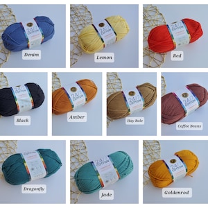 K&ouml;nnte beinhalten: Eine Auswahl von neun Kn&auml;ueln 24/7 Cotton-Garn in verschiedenen Farben, darunter Denim, Zitrone, Rot, Schwarz, Bernstein, Heuballen, Kaffeebohnen, Libelle, Jade und Goldrute. Jedes Kn&auml;uel ist mit seinem Farbnamen beschriftet.