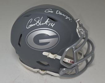 May include: Grey football helmet with a silver face mask and the letter "G" in silver. The helmet has the words "Go Dawgs!" and a signature with the number "14" in white. The helmet is a Riddell brand.