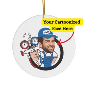 May include: A white ceramic ornament with a cartoon illustration of a person wearing a blue cap with the word "Mark" on it, holding a red and black gauge tool. The text "Your Cartoonized Face Here" is written in yellow on the ornament.