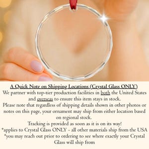 May include: A circular, clear glass ornament with a faceted edge and a small hole at the top for hanging. A thin, dark red ribbon is threaded through the top opening of the transparent, reflective glass disc, which catches light to create a bright flare.