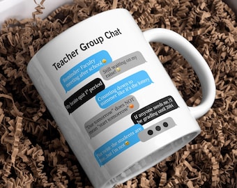 May include: White ceramic mug with the text "Teacher Group Chat" and humorous text message-style quotes about teaching. The mug is inside a white box filled with brown packing material.