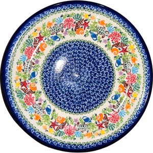 May include: A blue and white ceramic plate with a colorful sea life design. The plate features sea turtles, starfish, seashells, and coral.