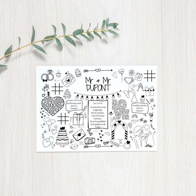 Op de afbeelding: Een zwart-witte printbare trouwkaart met een doodle-ontwerp. De kaart bevat een doolhof, harten, ringen, een camera, een taart en de tekst "Mr & Mr DUPONT".