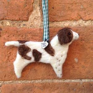 May include: A brown and white felt dog ornament with a heart-shaped tag that says "Made with Love".