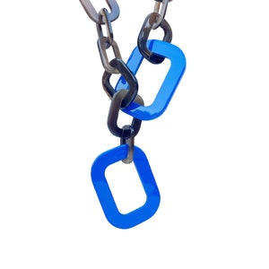 May include: A chain necklace with brown and black links. The chain has two blue rectangular links at the bottom.