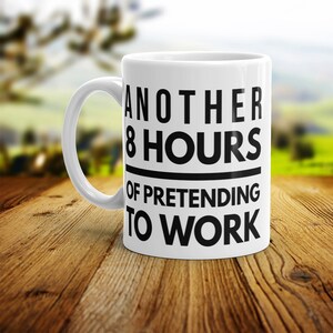 May include: White ceramic coffee mug with a black design that reads "Another 8 Hours of Pretending to Work".