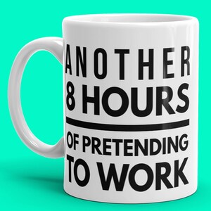 May include: White ceramic mug with black text that reads "Another 8 Hours of Pretending to Work".
