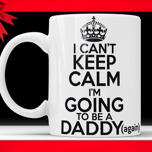 May include: White ceramic mug with a black crown and text that reads "I can't keep calm I'm going to be a daddy (again)"