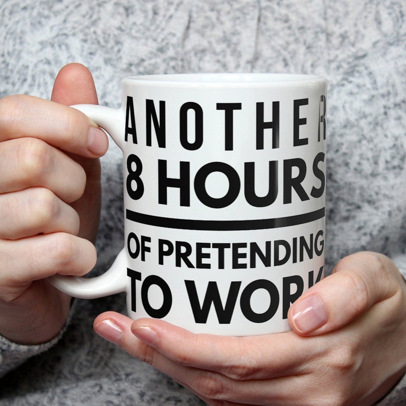 May include: White ceramic mug with black text that reads "Another 8 hours of pretending to work".