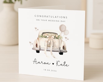 May include: A wedding card with a watercolor illustration of a vintage car decorated with flowers and a bow. The card reads "Congratulations on Your Wedding Day," with the names "Aaron ♥ Kate" and the date "18.04.2026" below the car. Two balloons float above the car.