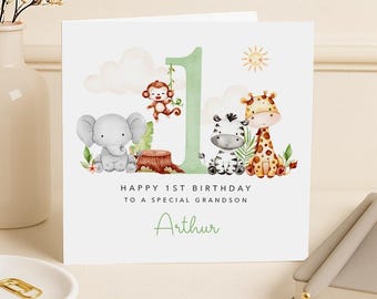 May include: A white greeting card with a jungle theme. The card features illustrations of an elephant, monkey, zebra, and giraffe. The number 1 is in green, and the text reads "HAPPY 1ST BIRTHDAY TO A SPECIAL GRANDSON Arthur."